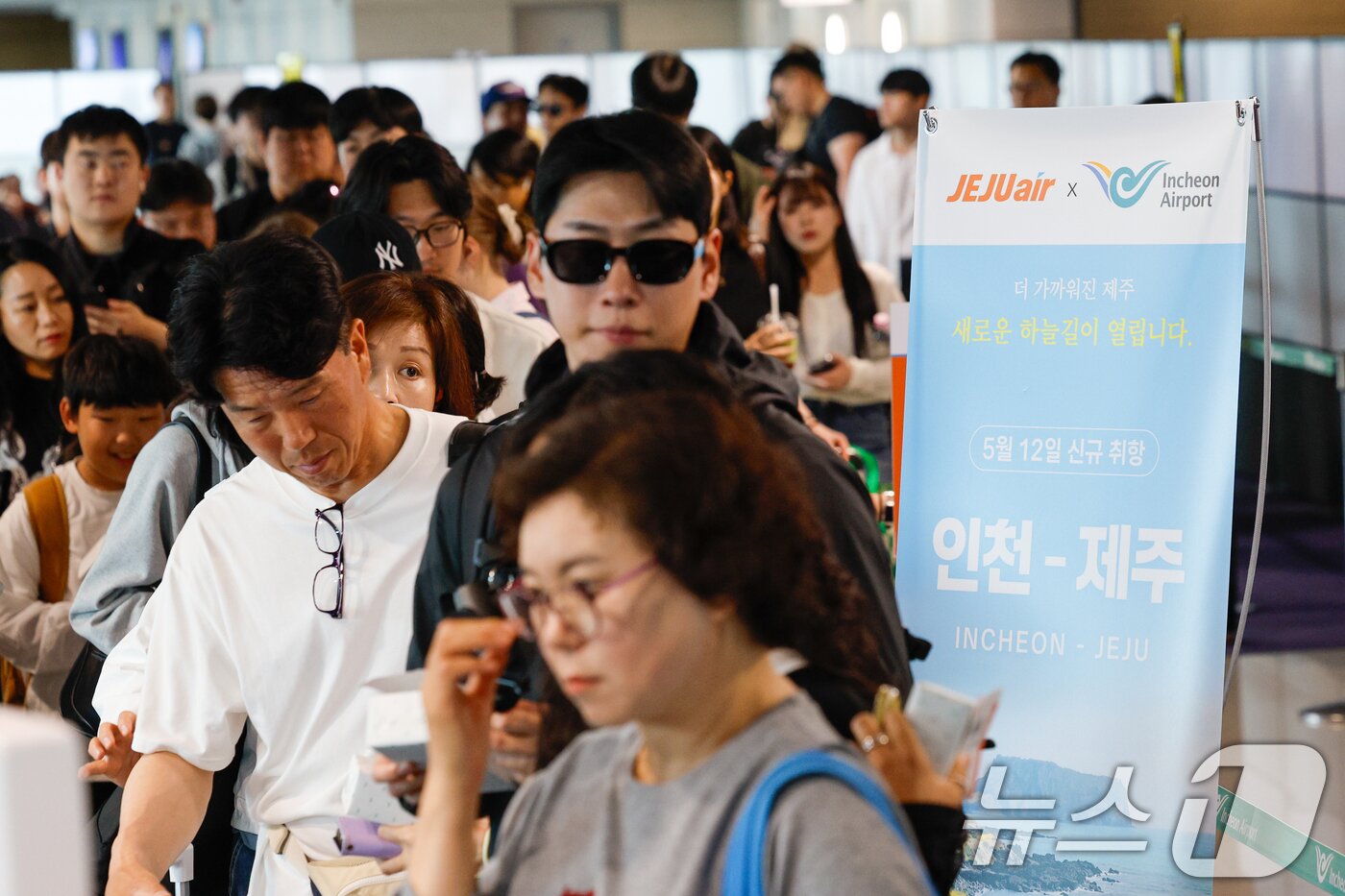 본문 이미지 - 인천-제주 국내선 직항노선이 10년만에 운영을 재개한 12일 인천국제공항 1터미널에서 제주로 향하는 제주항공 승객들이 탑승 수속을 밟고 있다. 2026.5.12 ⓒ 뉴스1 안은나 기자
