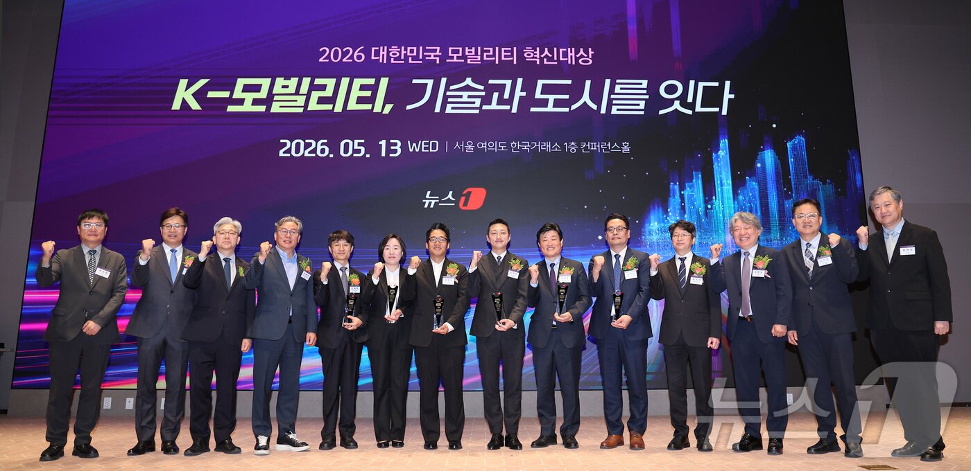 본문 이미지 - 이영섭 뉴스1 대표이사가 13일 서울 영등포구 여의도 한국거래소 컨퍼런스홀에서 열린 '2026 대한민국 모빌리티 혁신대상'에서 참석자들과 기념촬영을 하고 있다. 왼쪽부터 채원배 뉴스1 편집인 겸 전무이사, 이동민 서울시립대학교 교통공학과 교수, 이영섭 뉴스1 대표이사, 손명수 국회 국토교통위원회 위원, 박재범 한국도로공사 연구처장, 김정현 우진산전 대표, 윤동수 기아 국내커뮤니케이션 팀장, 강대권 SR 대표이사, 김정훈 대우건설 토목사업본부 상무, 김기용 한국교통안전공단 모빌리티지원센터장, 홍지선 국토교통부 제2차관, 유정훈 대한교통학회 회장, 김기성 뉴스1 편집국장, 윤태형 뉴스1 상무. 2026.5.13 ⓒ 뉴스1 김성진 기자