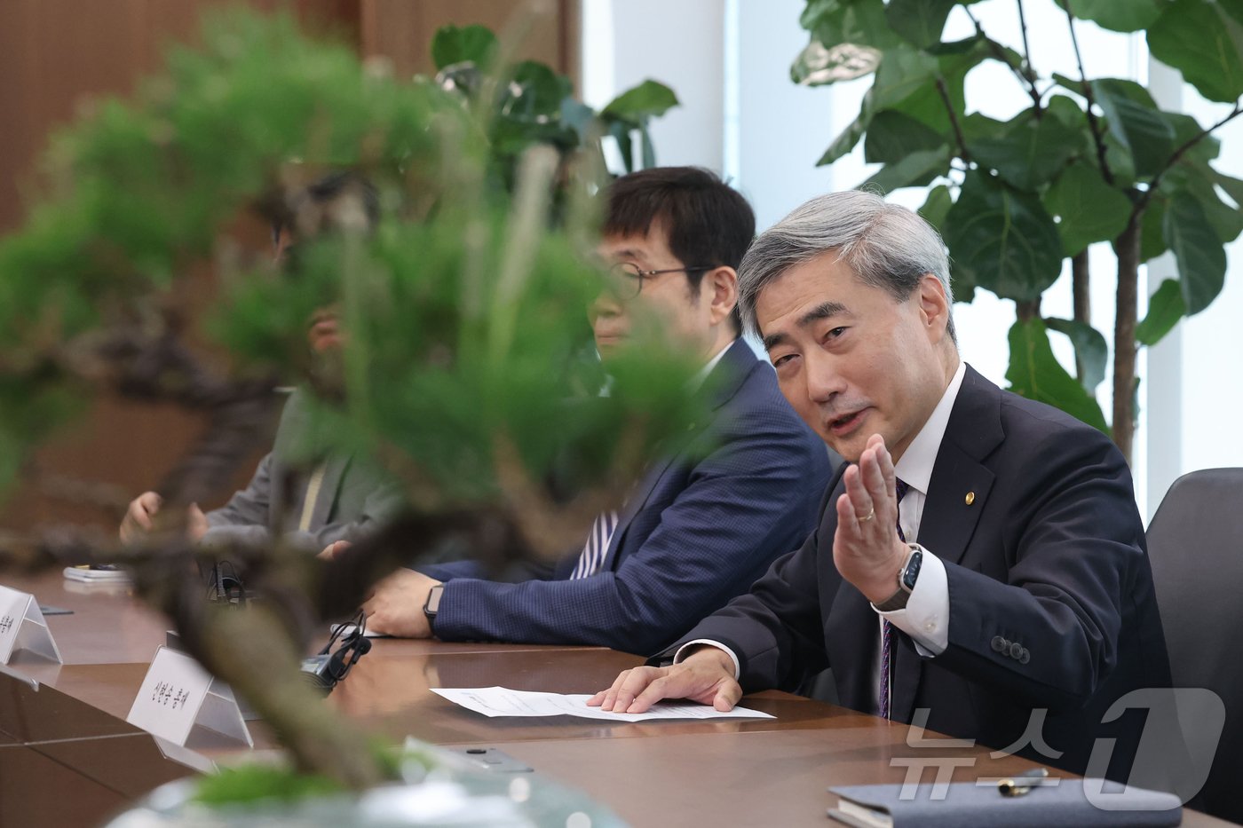 (서울=뉴스1) 오대일 기자 = 신현송 한국은행 총재가 14일 서울 중구 한국은행에서 박홍근 기획예산처 장관과 회동하며 선물받은 소나무 분재를 바라보고 있다. (공동취재)