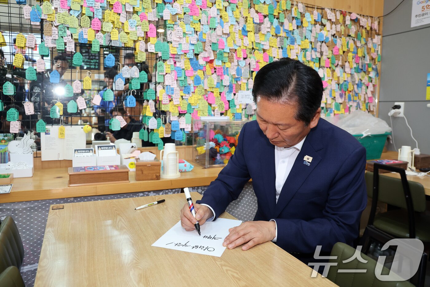 본문 이미지 - 정청래 더불어민주당 대표가 14일 경북 울릉군 저동 시가지의 한 식당에서 사인을 하고 있다. 2026.5.14 ⓒ 뉴스1 황기선 기자