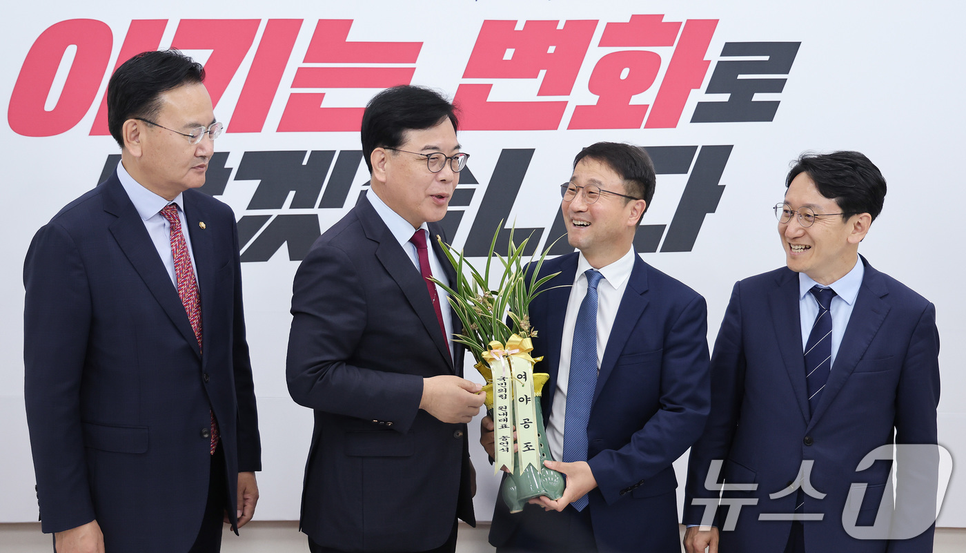 (서울=뉴스1) 신웅수 기자 = 연임된 한병도 더불어민주당 원내대표가 14일 서울 여의도 국회에서 송언석 국민의힘 원내대표를 예방하며 축하난을 선물받고 있다. 2026.5.14/뉴 …