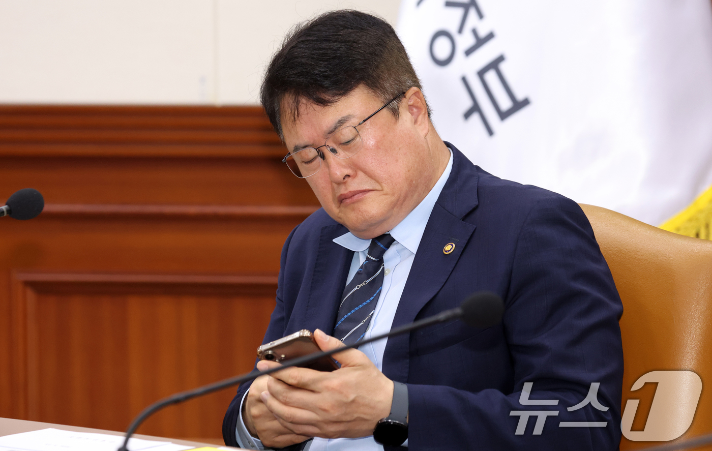 (서울=뉴스1) 김명섭 기자 = 김대현 문화체육관광부 2차관이 15일 서울 종로구 세종대로 정부서울청사에서 열린 비상경제본부회의 겸 경제관계장관회의에서 휴대폰을 살펴보고 있다. 2 …