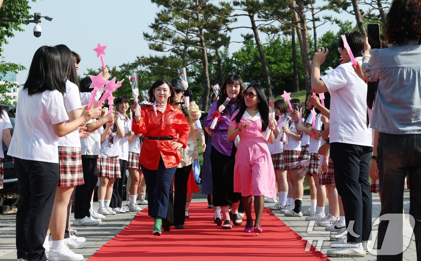 본문 이미지 - 스승의 날인 15일 경기 수원시 팔달구 매향중학교에서 열린 스승의 날 기념 등굣길 레드카펫 행사에서 선생님들이 레드카펫에 올라 학생들에게 감사 인사를 전하고 있다. 올해로 5회째를 맞은 이번 행사는 학생회 학생들이 주도적으로 참여해 선생님들의 헌신과 노고에 대한 존경과 감사의 마음을 전했다. 2026.5.15 ⓒ 뉴스1 김영운 기자