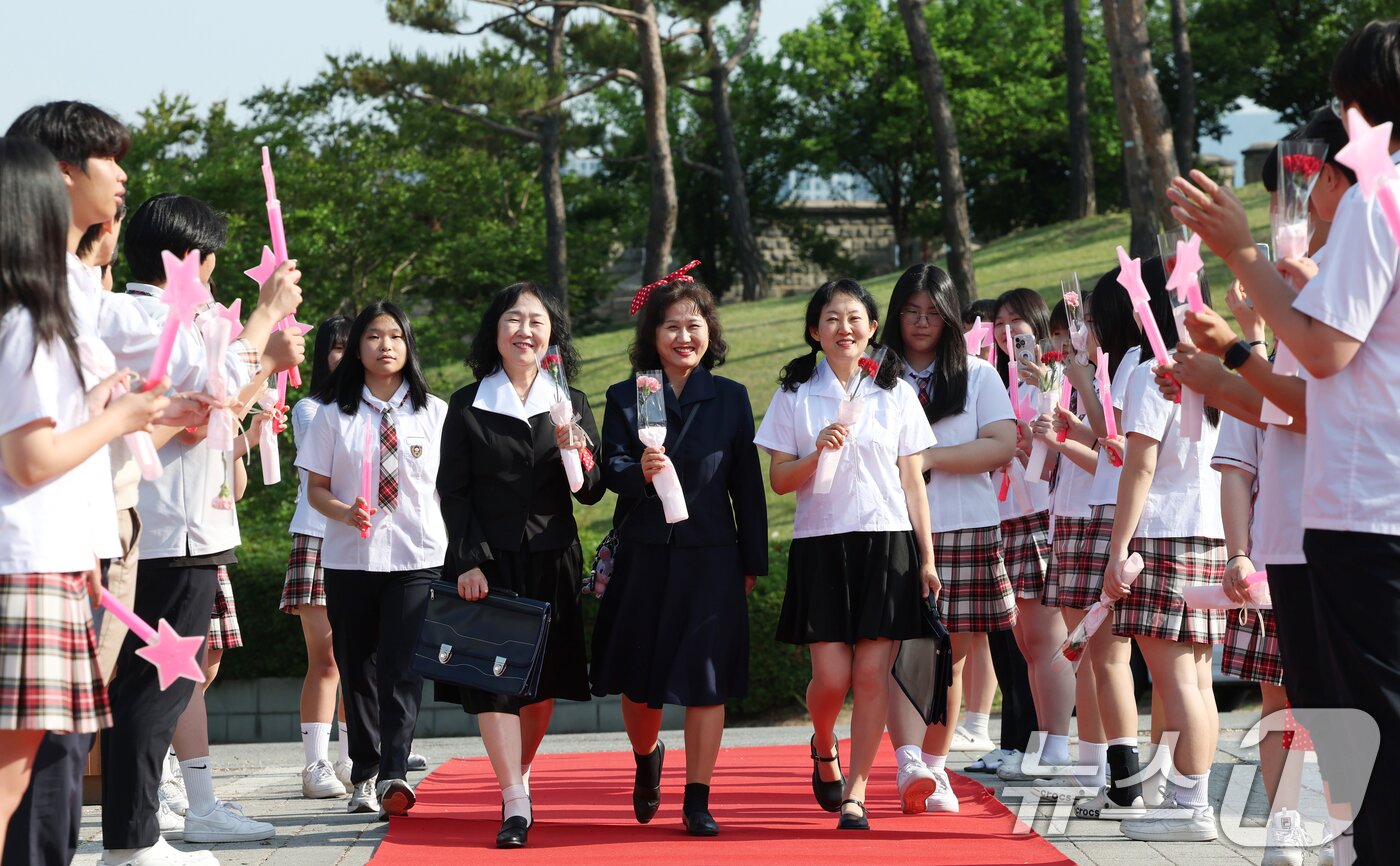 본문 이미지 - 스승의 날인 15일 경기 수원시 팔달구 매향중학교에서 열린 스승의 날 기념 등굣길 레드카펫 행사에서 선생님들이 레드카펫에 올라 학생들에게 감사 인사를 전하고 있다. 올해로 5회째를 맞은 이번 행사는 학생회 학생들이 주도적으로 참여해 선생님들의 헌신과 노고에 대한 존경과 감사의 마음을 전했다. ⓒ 뉴스1 김영운 기자