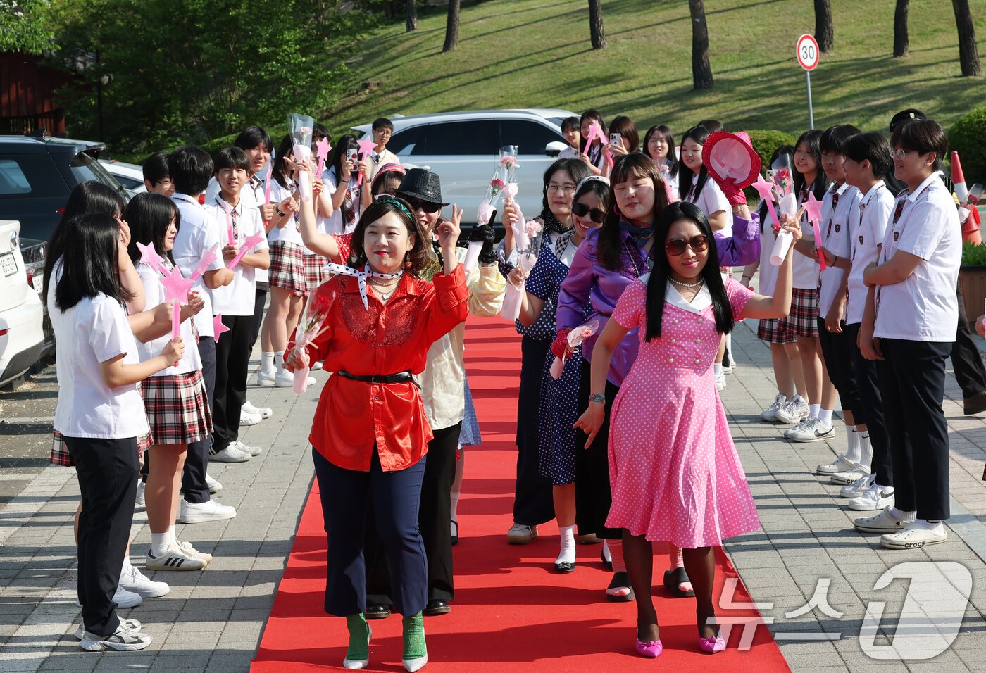 본문 이미지 - 스승의 날인 15일 경기 수원시 팔달구 매향중학교에서 열린 스승의 날 기념 등굣길 레드카펫 행사에서 선생님들이 레드카펫에 올라 학생들에게 감사 인사를 전하고 있다. 올해로 5회째를 맞은 이번 행사는 학생회 학생들이 주도적으로 참여해 선생님들의 헌신과 노고에 대한 존경과 감사의 마음을 전했다. 2026.5.15 ⓒ 뉴스1 김영운 기자
