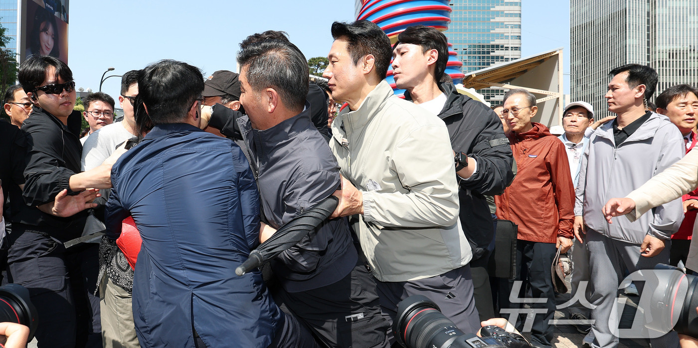 (서울=뉴스1) 박지혜 기자 = 이명박 전 대통령이 15일 서울 청계광장에서 오세훈 국민의힘 서울시장 후보와 환담을 나누던 중 남성이 "용산참사 책임자"라고 외치며 이 전 대통령에 …