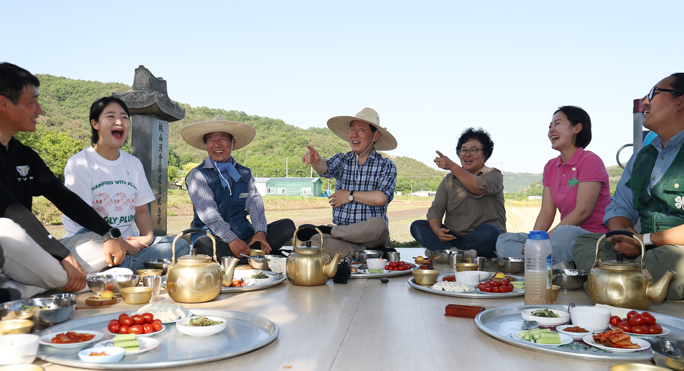 (대구=뉴스1) 허경 기자 = 이재명 대통령이 15일 대구 군위군 소보면 모내기 현장을 방문해 주민들과 새참 간담회 중 미소를 짓고 있다. 2026.5.15/뉴스1