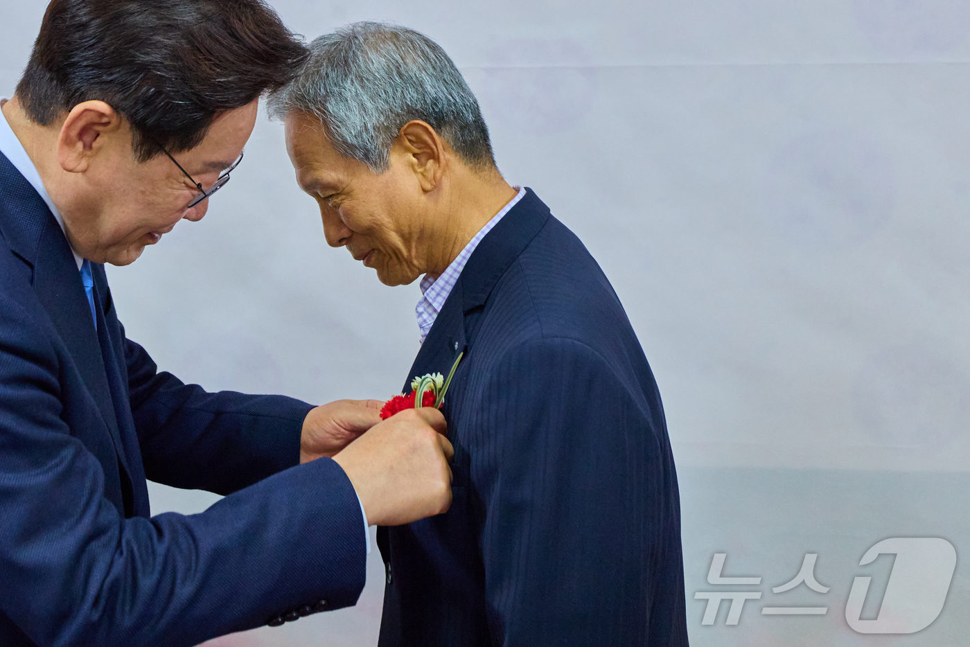 (서울=뉴스1) = 이재명 대통령이 스승의날인 15일 경북 안동의 한 식당에서 초등학교 시절 은사인 박병기 선생님에게 카네이션을 달아드리고 있다. (청와대 제공. 재판매 및 DB …
