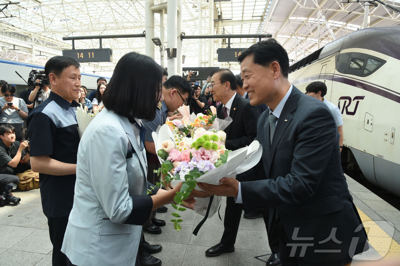 (서울=뉴스1) = 정왕국 에스알 대표이사가 KTX와 SRT를 연결해 운행하는 중련 열차 시범 운행 첫날인 15일 서울역 승강장에서 KTX 승무원에게 꽃다발을 전하고 있다. (에스 …