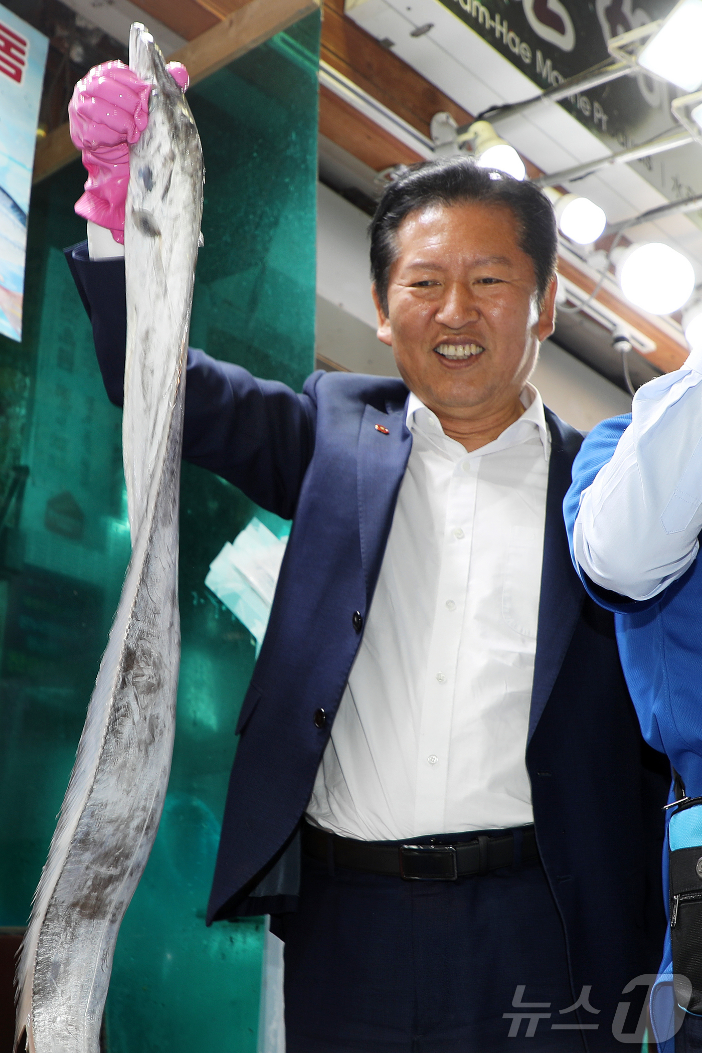(제주=뉴스1) 오미란 기자 = 정청래 더불어민주당 대표가 15일 오후 서귀포매일올레시장을 방문해 갈치를 들어 보이고 있다. 2026.5.15/뉴스1