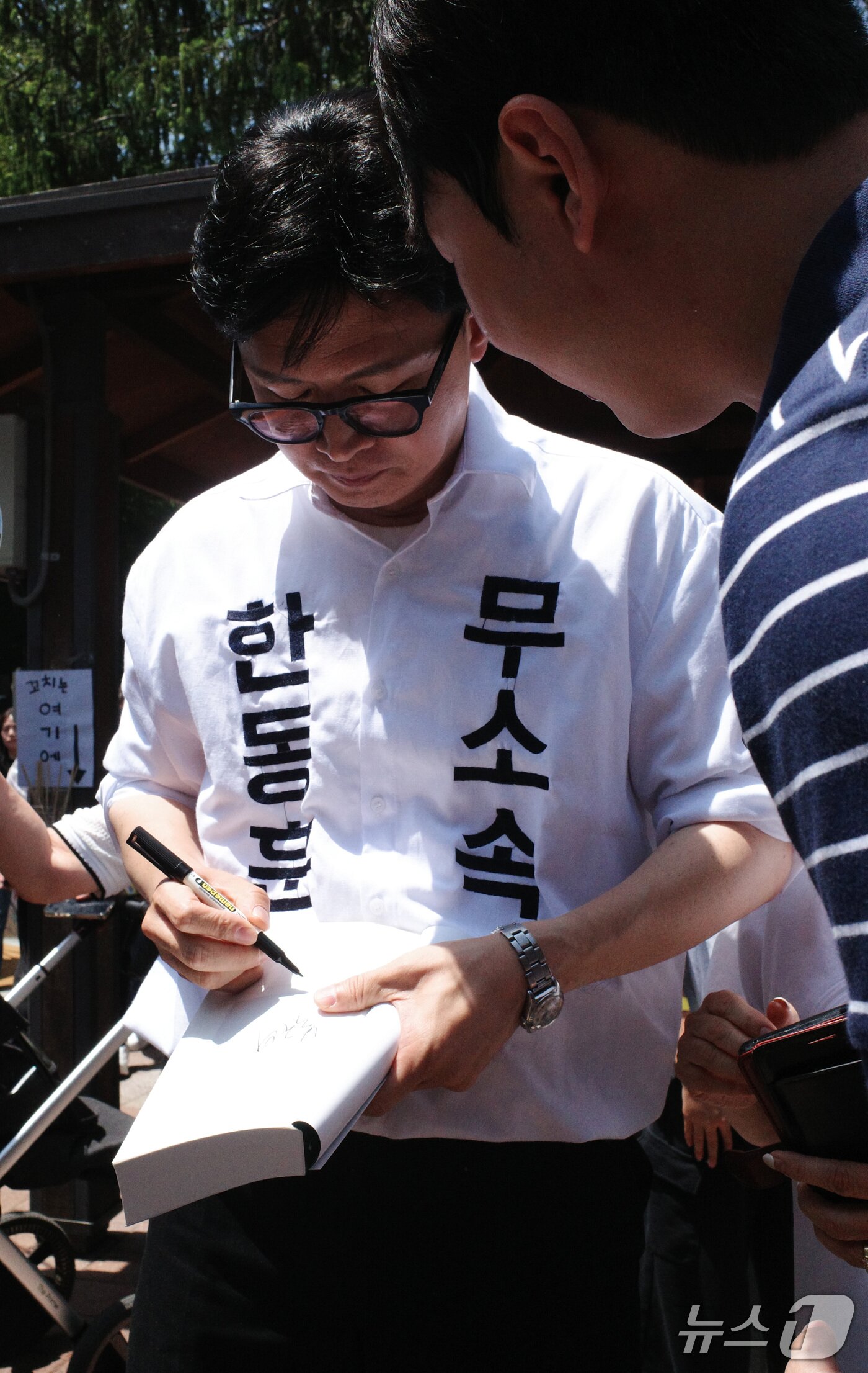 본문 이미지 - 한동훈 무소속 부산 북구갑 국회의원 보궐선거 후보가 16일 부산 북구 만덕동 백양근린공원에서 열린 만덕지기 마을축제에서 지역주민에게 사인을 해주고 있다. 2026.05.16 ⓒ 뉴스1 김세정 기자
