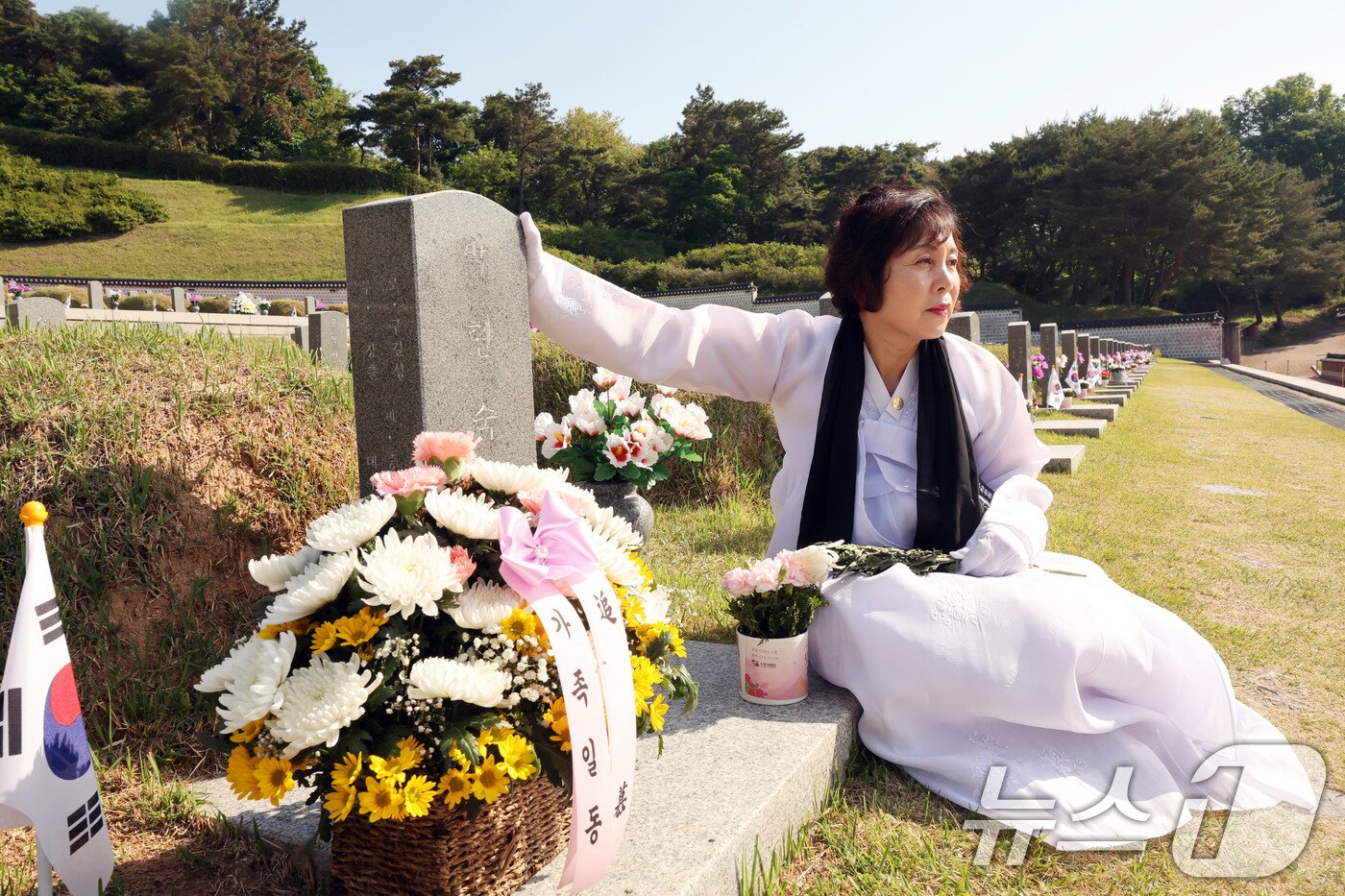 본문 이미지 - 제 46주년 5·18민주화운동 기념일을 하루 앞둔 17일 희생자 시신을 모실 관을 구하러 가다 계엄군 총격에 숨진 박현숙 열사의 가족이 국립 5·18민주묘지에서 그를 그리워하고 있다. 2026.5.17 ⓒ 뉴스1 박지현 기자