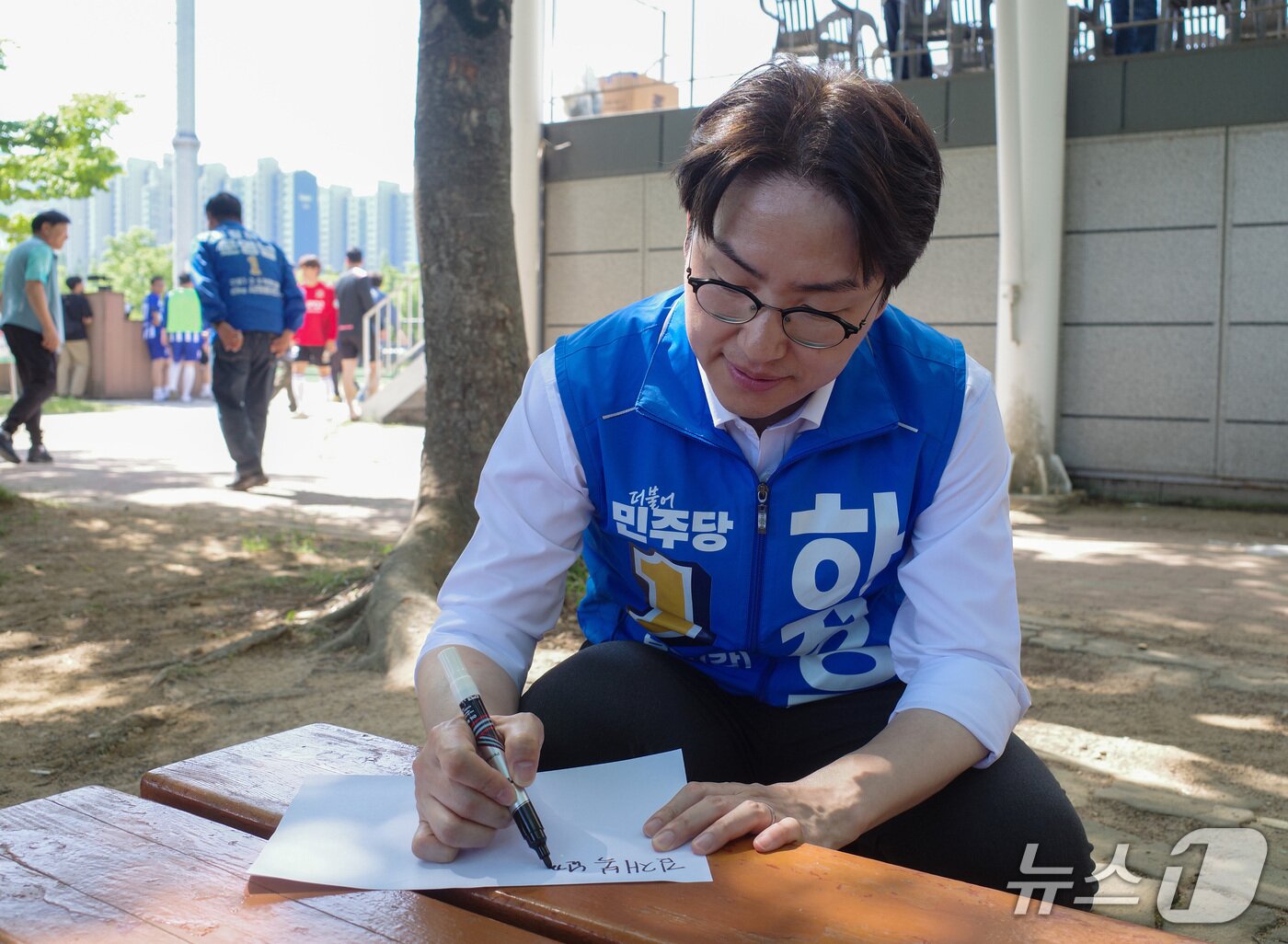 본문 이미지 - 하정우 더불어민주당 부산 북구갑 국회의원 보궐선거 후보가 17일 부산 북구 화명생태공원에서 열린 북구축구협회장기 대회 현장에서 한 주민에게 사인을 해주고 있다. 2026.05.17 ⓒ 뉴스1 김세정 기자