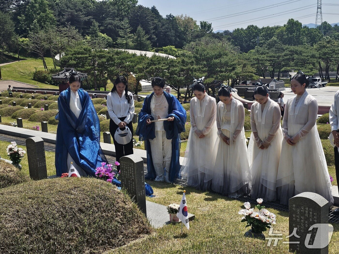 본문 이미지 - 17일 제46주년 5·18민주화운동 추모식에서 추모 공연을 마친 김연우 씨와 동료들이 국립 5·18민주묘역에 안장돼 있는 연우 씨의 아버지 고 김영철 시민군 기획실장 묘비에 묵념을 올리고 있다. 2026.5.17/뉴스1 최성국 기자