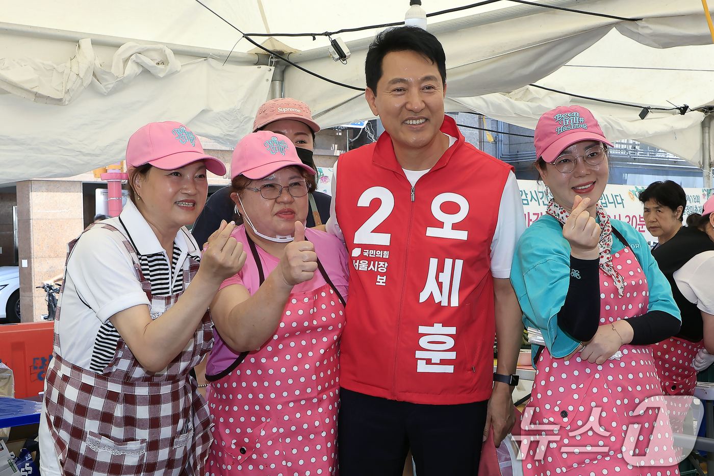 (서울=뉴스1) 박정호 기자 = 오세훈 국민의힘 서울시장 후보가 17일 오후 서울시 중랑구 묵동 중랑천 중화수경공원 일대에서 열린 중랑 서울장미축제를 방문해 상인들과 기념 촬영을 …