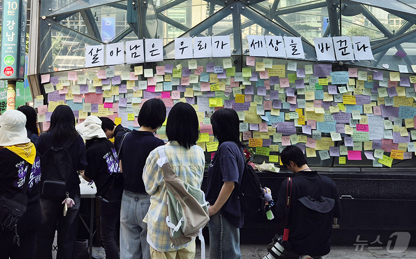 (서울=뉴스1) 신윤하 기자 = 강남역 여성 살해사건 10주기 추모행동 행사가 열린 17일 서울 지하철 강남역 10번 출구 앞 도로에서 시민들이 추모의 문구를 붙이고 있다. 202 …