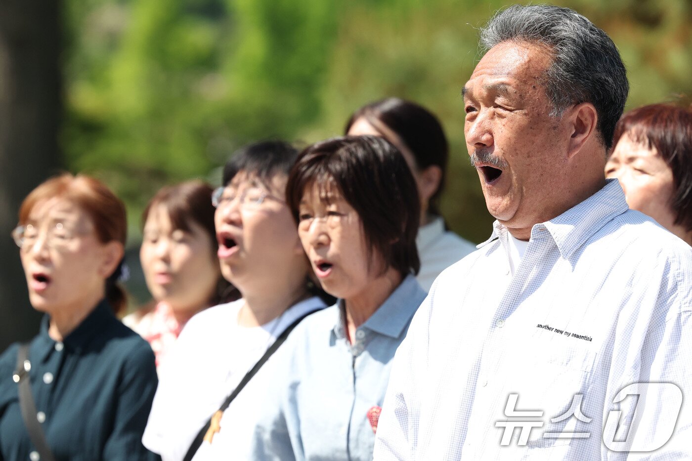 본문 이미지 - 제46주년 5·18민주화운동기념일인 18일 광주 북구 망월동에 위치한 민족민주열사묘역(구묘역)에서 일본 일어서라 합창단원들이 임을 위한 행진곡을 부르고 있다. 2026.5.18 ⓒ 뉴스1 이승현 기자
