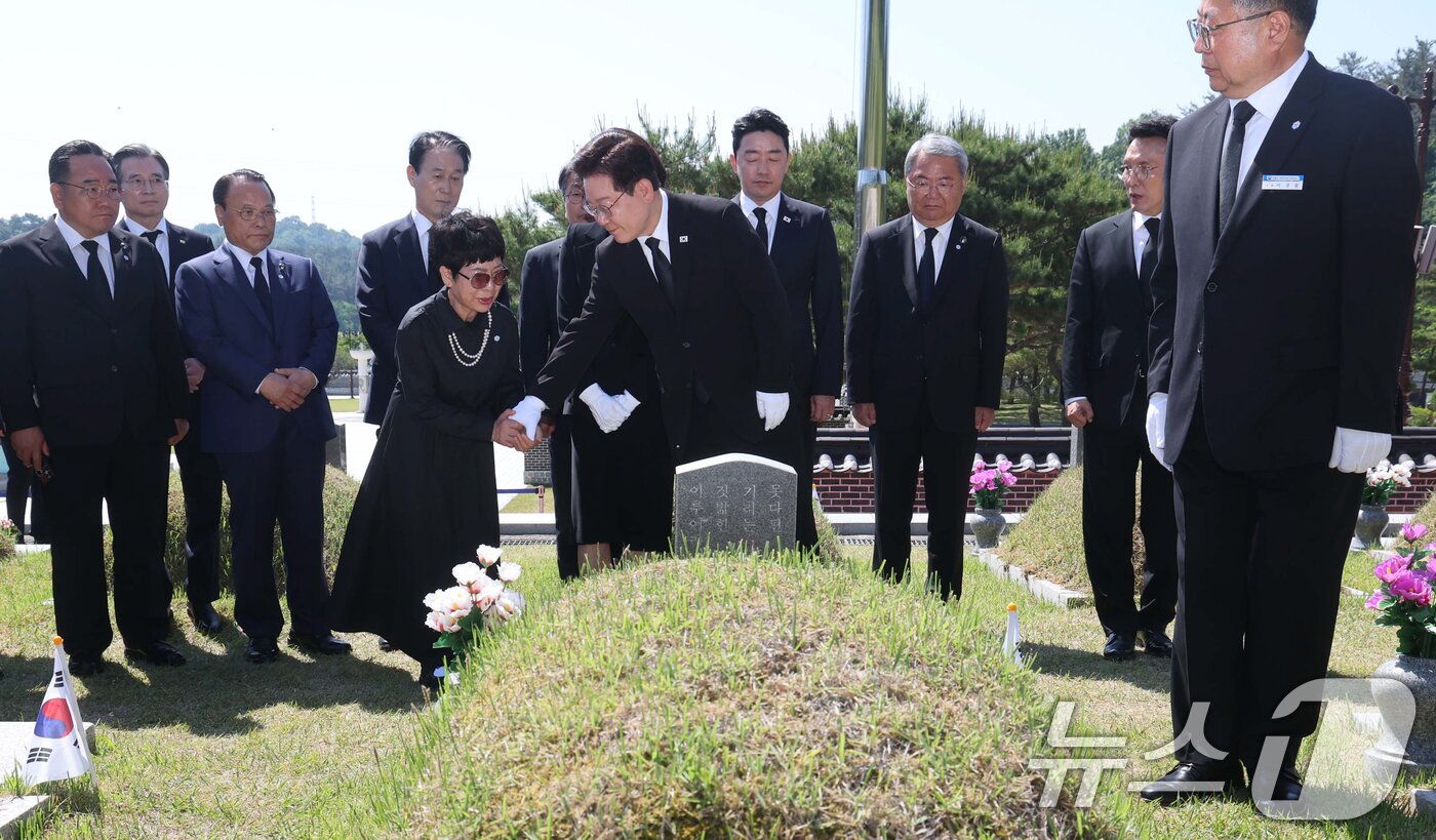 본문 이미지 - 이재명 대통령이 18일 오전 광주 북구 운정동 국립 5·18민주묘지을 찾아 故 박인배 묘역에 헌화한 뒤 유가족을 위로하고 있다. 2026.5.18 ⓒ 뉴스1 이재명 기자