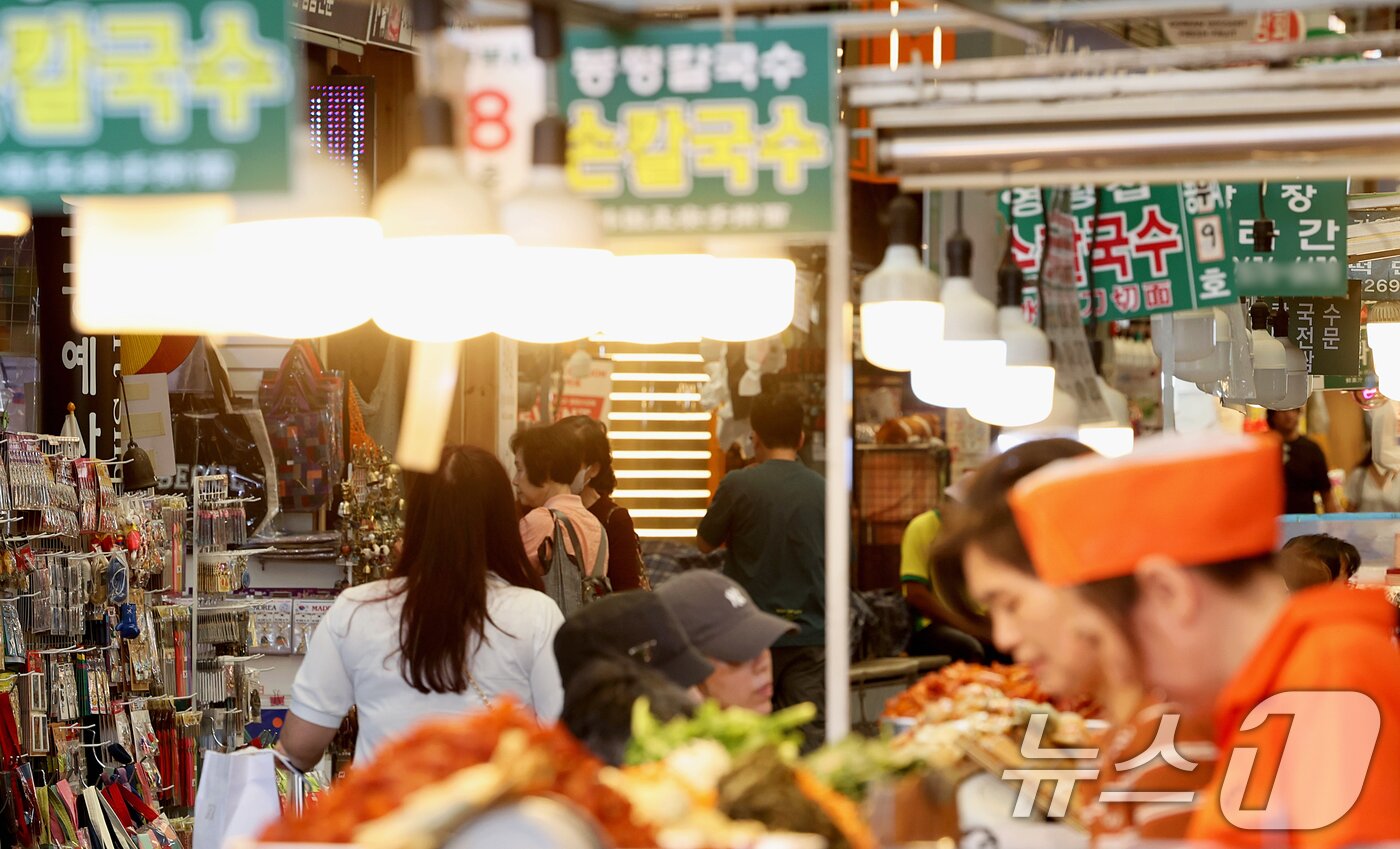 본문 이미지 - 18일 오전 서울 종로구 광장시장에서 외국인 관광객들이 먹거리를 구매하고 있다. 2026.5.18 ⓒ 뉴스1 조연우 인턴기자