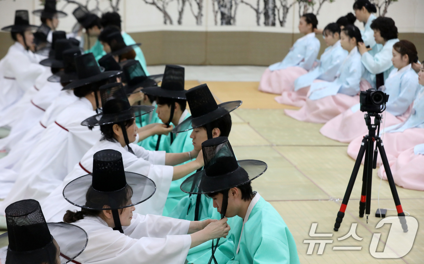 (부산=뉴스1) 윤일지 기자 = 성년의 날인 18일 오후 부산 사상구 부산시여성문화회관 대강당에서 열린 '전통 성년례'에서 남성 참가자들이 갓을 쓰는 관례 의식을 하고 있다.  2 …