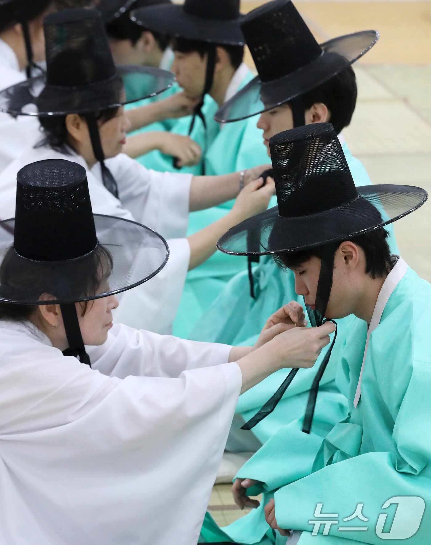 본문 이미지 - 성년의 날인 18일 오후 부산 사상구 부산시여성문화회관 대강당에서 열린 '전통 성년례'에서 남성 참가자들이 갓을 쓰는 관례 의식을 하고 있다. 2026.5.18 ⓒ 뉴스1 윤일지 기자