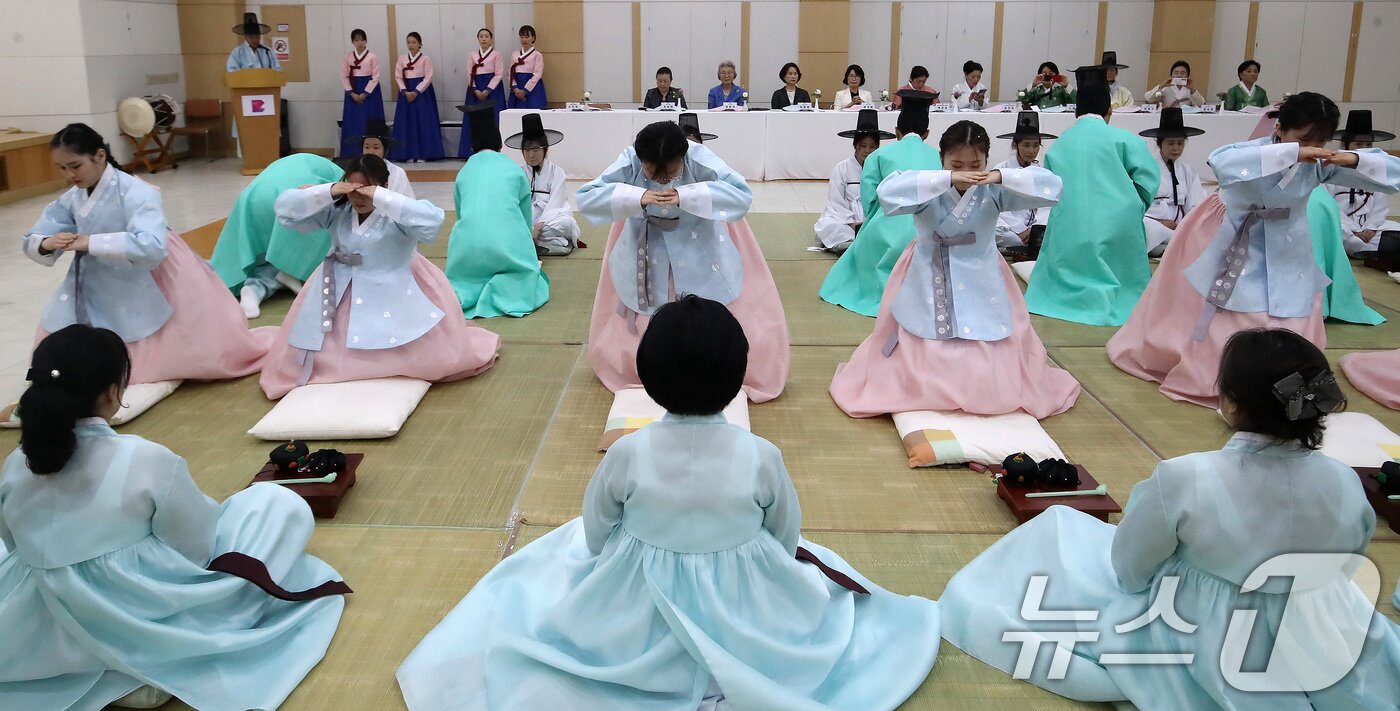 본문 이미지 - 성년의 날인 18일 오후 부산 사상구 부산시여성문화회관 대강당에서 열린 '전통 성년례'에서 남녀 참가자들이 큰절을 하고 있다. 2026.5.18 ⓒ 뉴스1 윤일지 기자