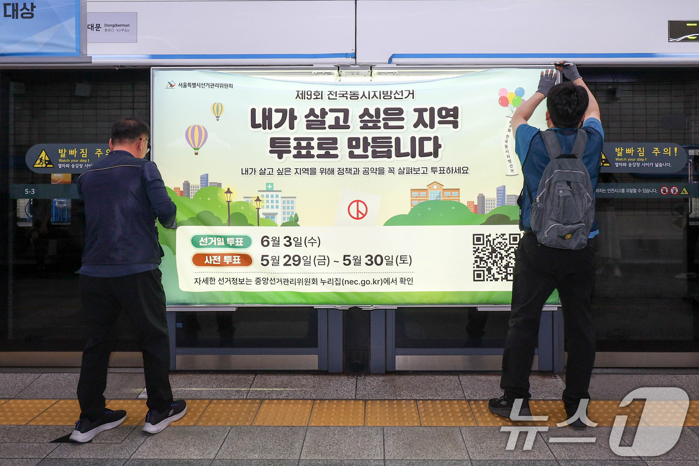 (서울=뉴스1) 이광호 기자 = 제9회 전국동시지방선거를 보름 앞둔 19일 서울 종로구 지하철 4호선 혜화역 사당방향 승강장에서 서울시선관위 관계자들이 스크린도어에 선거 홍보물을 …