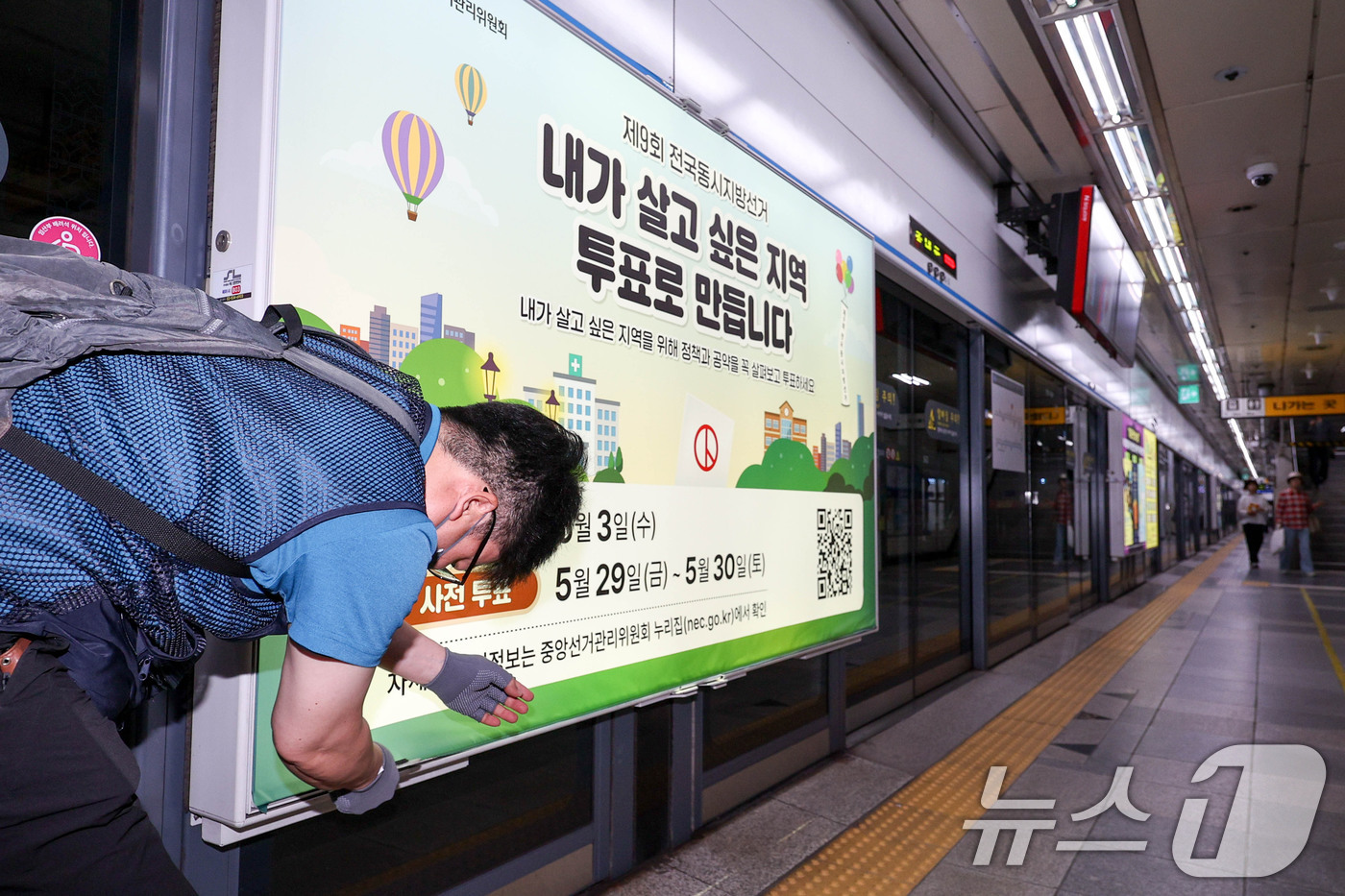 (서울=뉴스1) 이광호 기자 = 제9회 전국동시지방선거를 보름 앞둔 19일 서울 종로구 지하철 4호선 혜화역 사당방향 승강장에서 서울시선관위 관계자들이 스크린도어에 선거 홍보물을 …