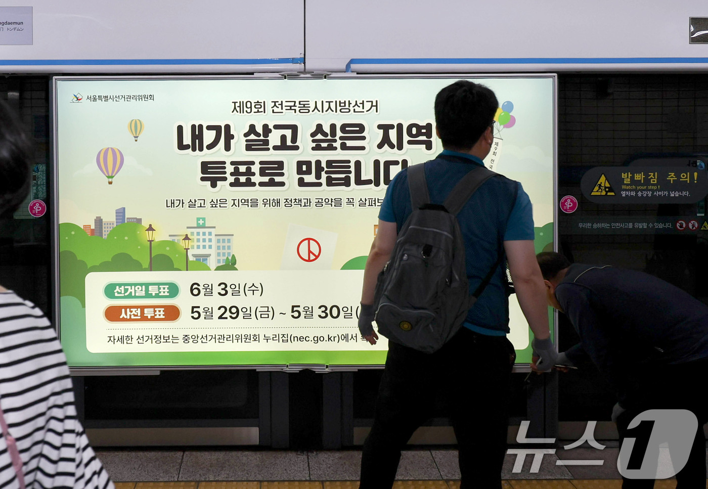 (서울=뉴스1) 이광호 기자 = 제9회 전국동시지방선거를 보름 앞둔 19일 서울 종로구 지하철 4호선 혜화역 사당방향 승강장에서 서울시선관위 관계자들이 스크린도어에 선거 홍보물을 …