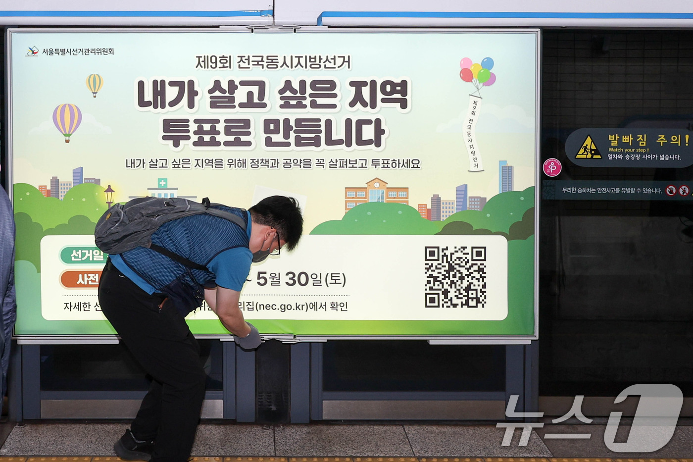 (서울=뉴스1) 이광호 기자 = 제9회 전국동시지방선거를 보름 앞둔 19일 서울 종로구 지하철 4호선 혜화역 사당방향 승강장에서 서울시선관위 관계자들이 스크린도어에 선거 홍보물을 …