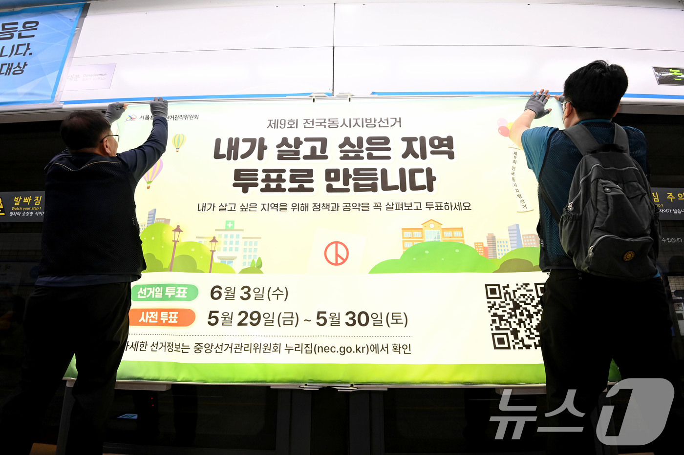(서울=뉴스1) 이광호 기자 = 제9회 전국동시지방선거를 보름 앞둔 19일 서울 종로구 지하철 4호선 혜화역 사당방향 승강장에서 서울시선관위 관계자들이 스크린도어에 선거 홍보물을 …