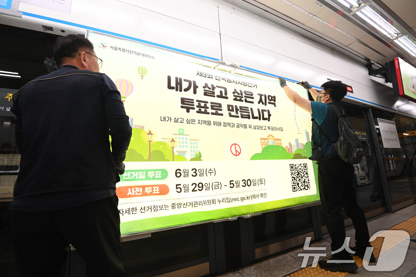 (서울=뉴스1) 이광호 기자 = 제9회 전국동시지방선거를 보름 앞둔 19일 서울 종로구 지하철 4호선 혜화역 사당방향 승강장에서 서울시선관위 관계자들이 스크린도어에 선거 홍보물을 …