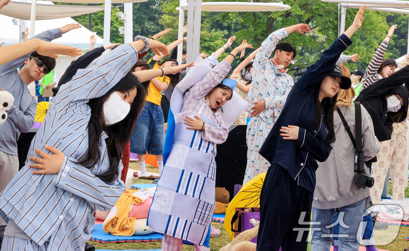본문 이미지 - 2일 서울 영등포구 한강공원 멀티플라자에서 열린 ‘2026 한강 잠퍼자기 대회’에 참가한 시민들이 낮잠 자기 전 수면 요가를 하고 있다.  2026.5.2 ⓒ 뉴스1 이호윤 기자
