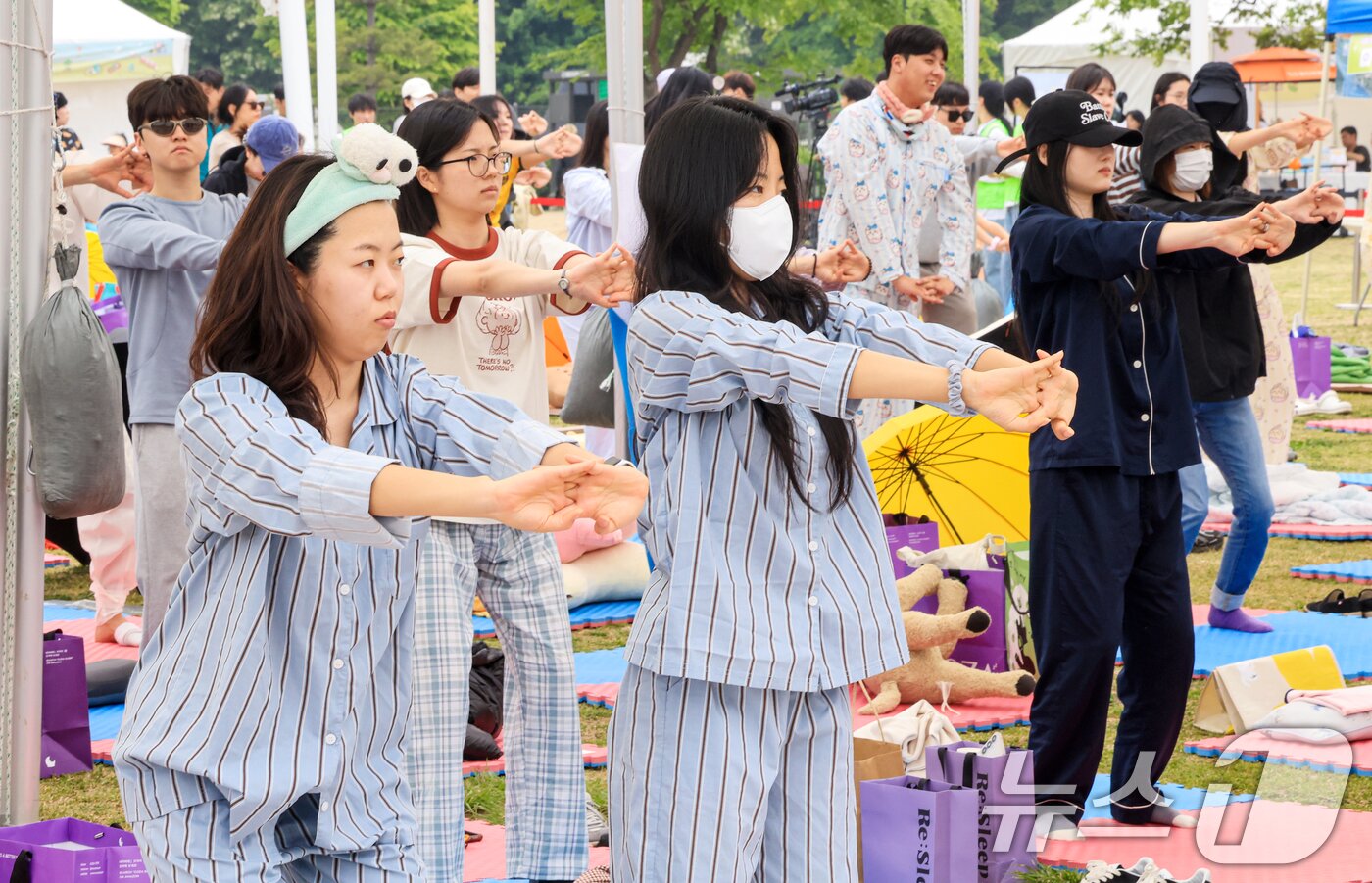 본문 이미지 - 2일 서울 영등포구 한강공원 멀티플라자에서 열린 ‘2026 한강 잠퍼자기 대회’에 참가한 시민들이 낮잠 자기 전 수면 요가를 하고 있다. 2026.5.2 ⓒ 뉴스1 이호윤 기자