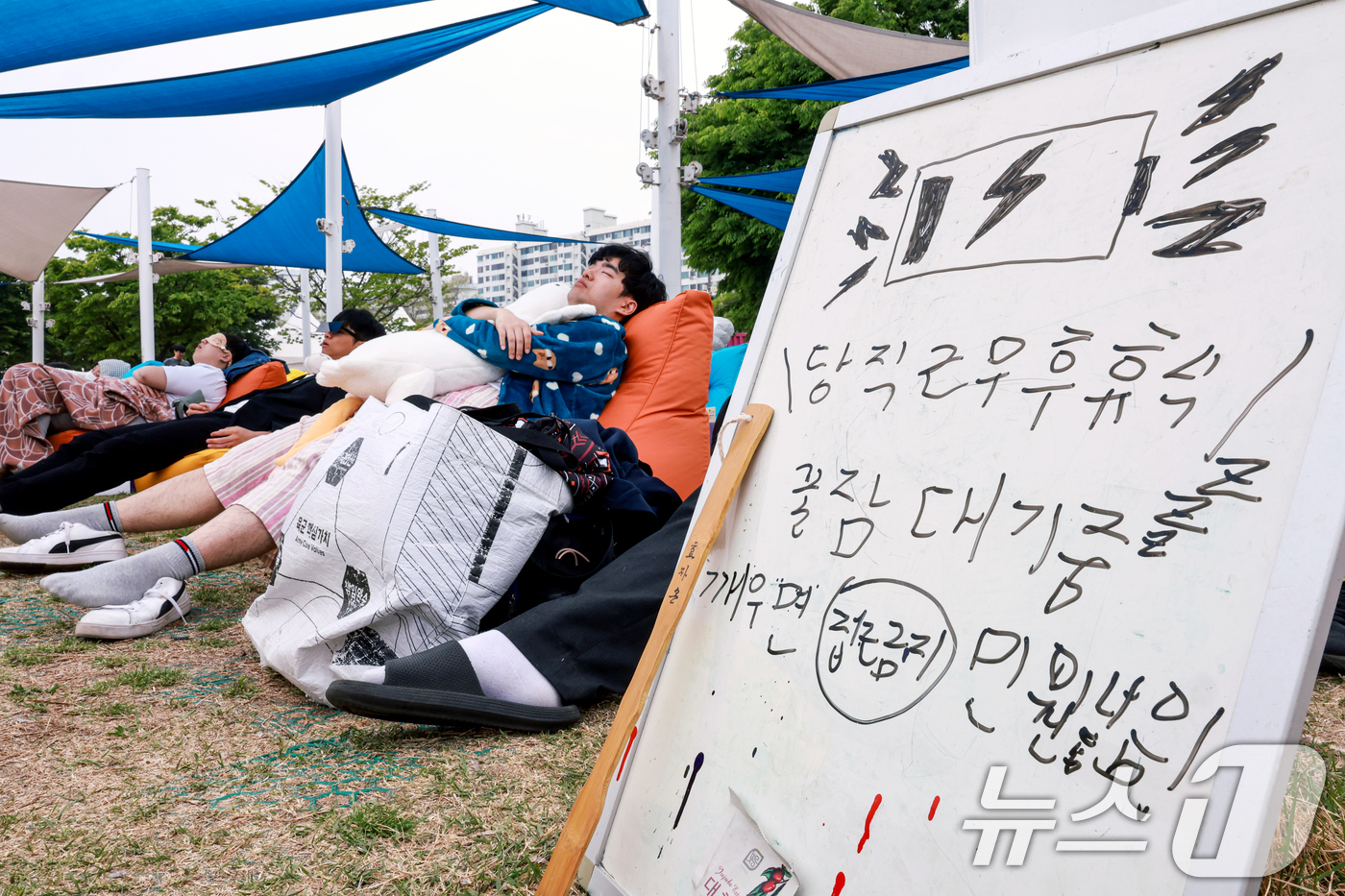(서울=뉴스1) 이호윤 기자 = 2일 서울 영등포구 한강공원 멀티플라자에서 열린 ‘2026 한강 잠퍼자기 대회’에 참가한 시민들이 낮잠을 자고 있다.2024년부터 시작한 한강 잠퍼 …