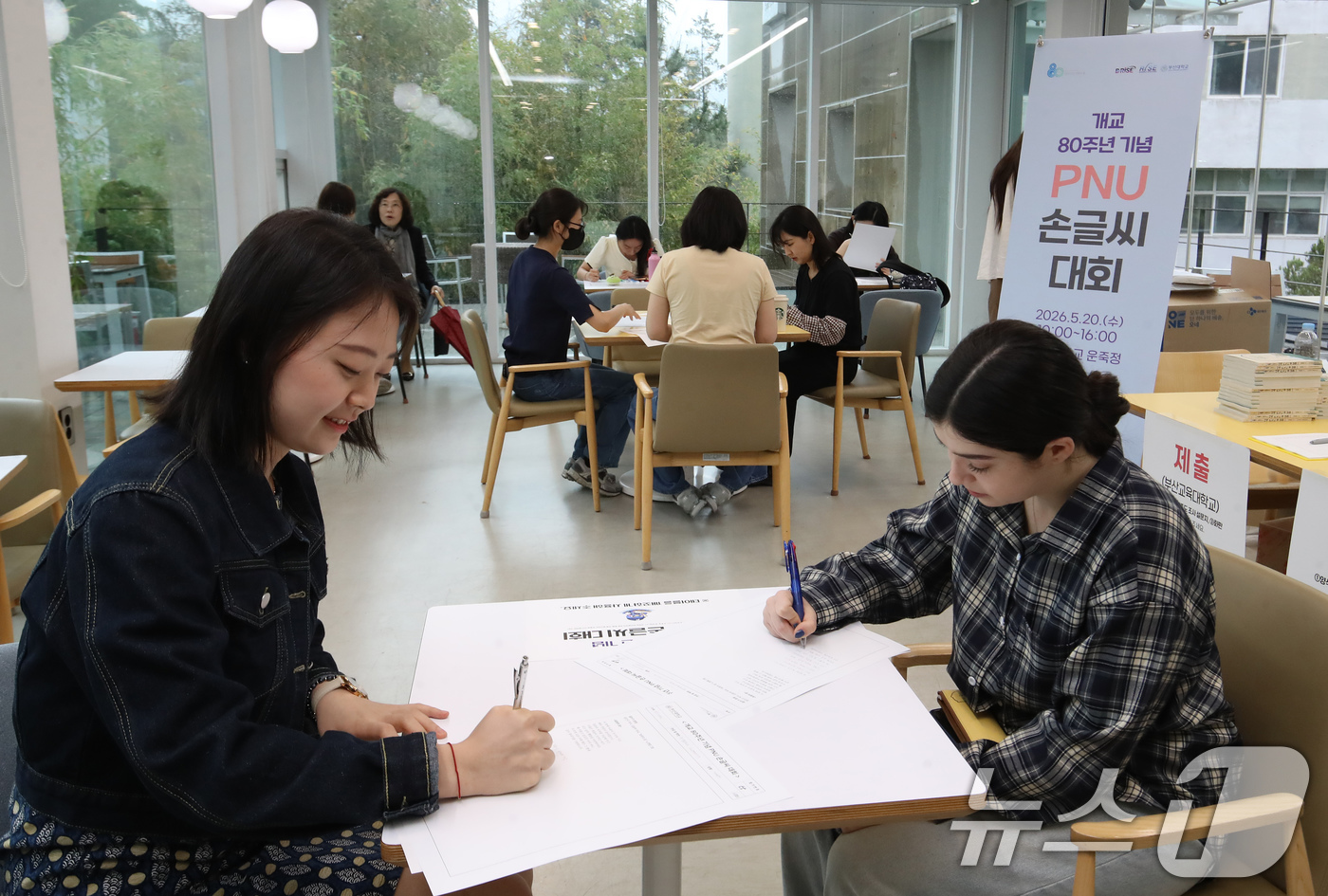 (부산=뉴스1) 윤일지 기자 = 20일 부산 금정구 부산대학교 운죽정에서 열린 '개교 80주년 기념 PNU 손글씨 대회'에서 외국인 유학생과 학생들이 손글씨 쓰고 있다.  2026 …