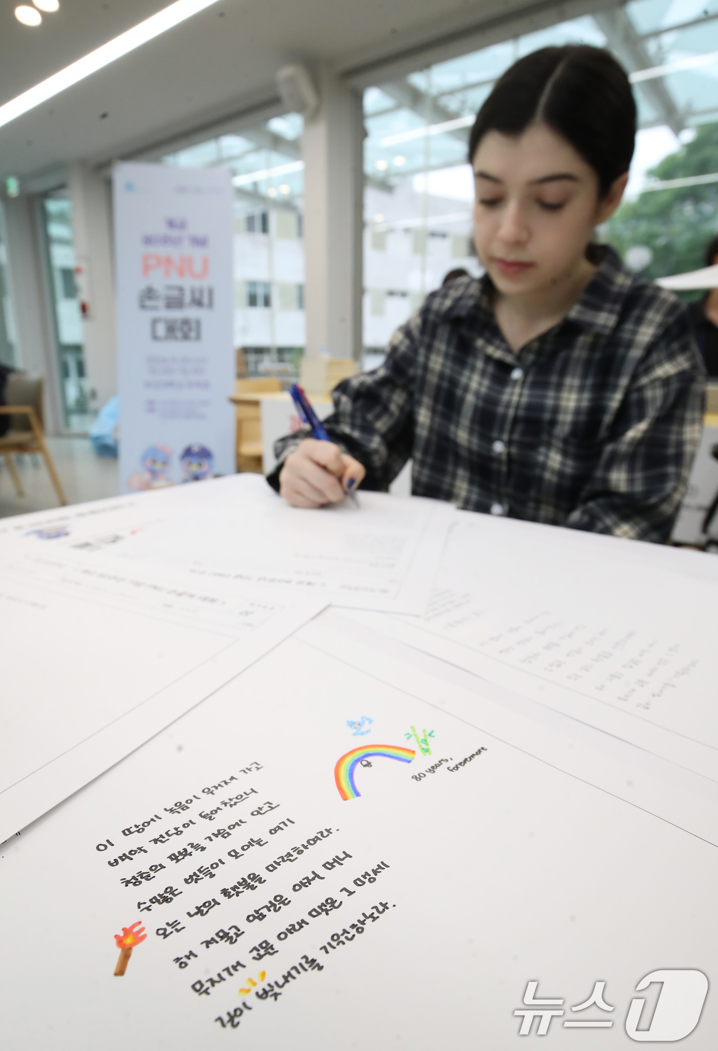 (부산=뉴스1) 윤일지 기자 = 20일 부산 금정구 부산대학교 운죽정에서 열린 '개교 80주년 기념 PNU 손글씨 대회'에서 외국인 유학생과 학생들이 손글씨 쓰고 있다.  2026 …