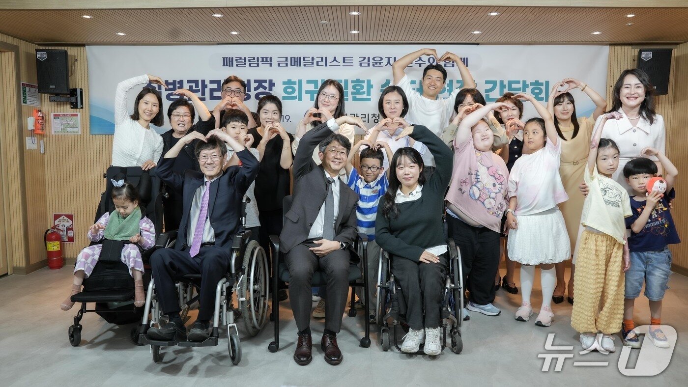본문 이미지 - 임승관 질병관리청장과 김윤지 패럴림픽 금메달리스트가 지난 19일 서울 서대문구의 한국희귀난치성질환연합회 현장 간담회 후 참석자들과 기념촬영을 진행했다.(질병관리청 제공)