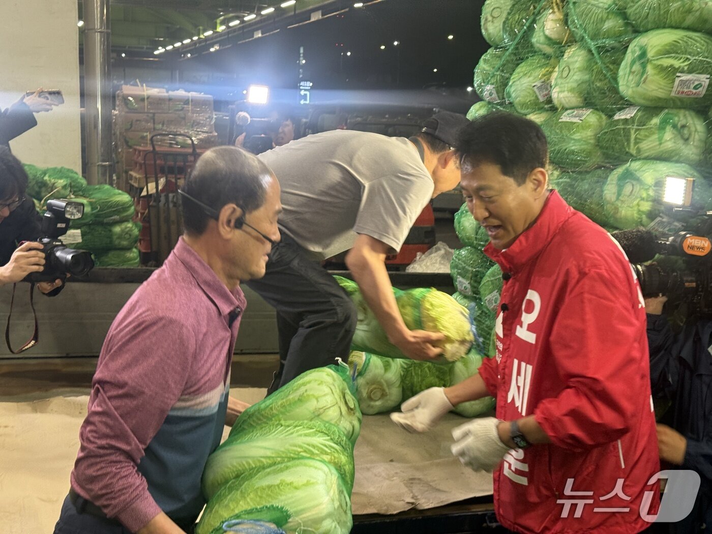 본문 이미지 - 오세훈 국민의힘 서울시장 후보가 공식선거운동이 시작되는 21일 송파구 가락동 농수산물 도매시장에서 배추를 나르고 있다(뉴스1 구진욱 기자)