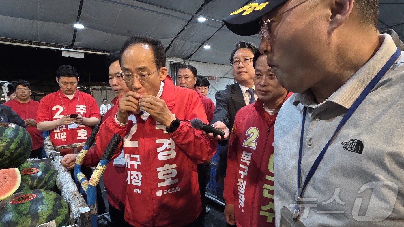 (대구=뉴스1) 이성덕 기자 = 추경호 국민의힘 대구시장 후보가 21일 대구농수산물도매시장에서 상인이 건넨 수박을 맛보고 있다. 2026.5.21/뉴스1