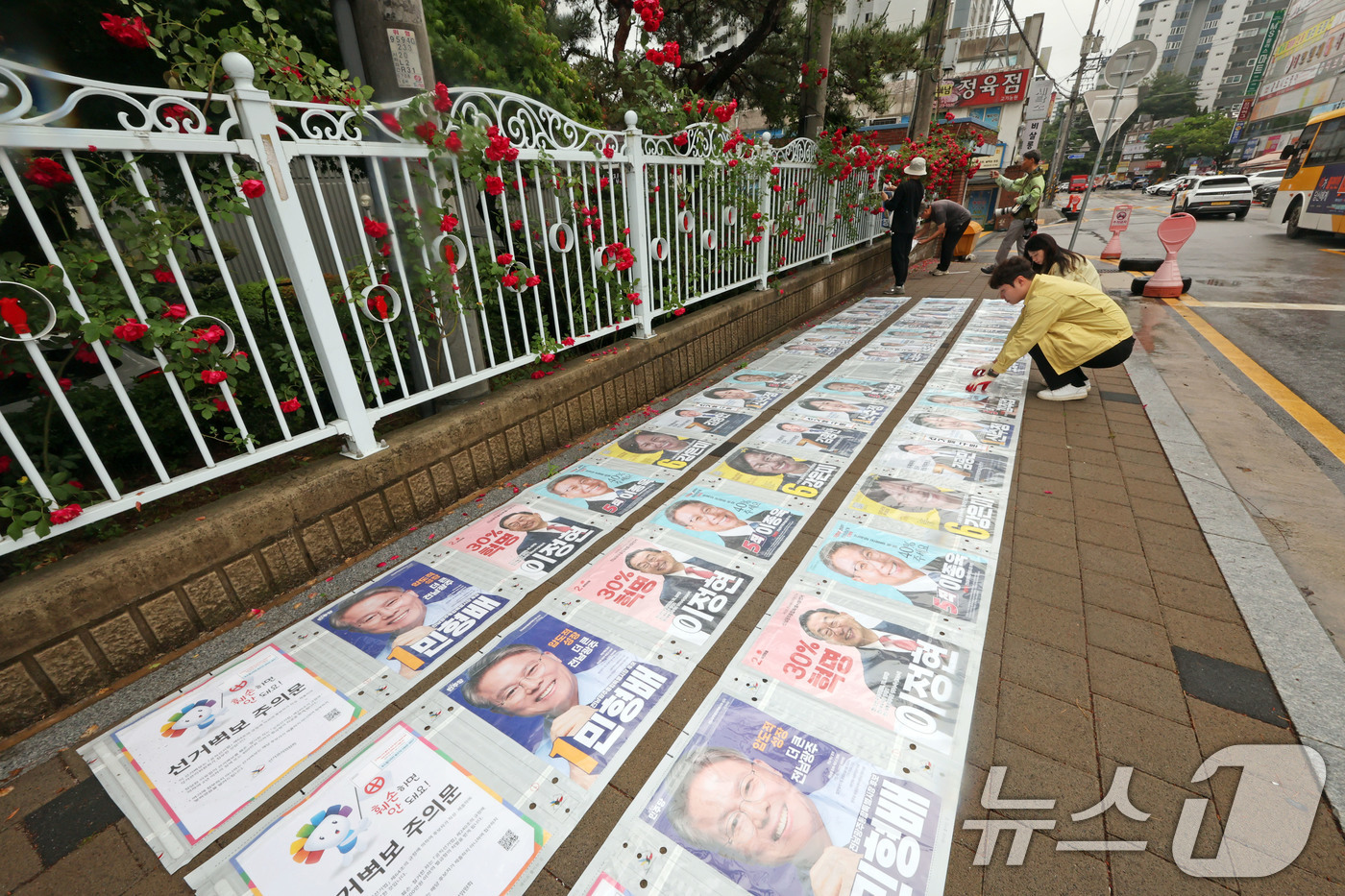 (광주=뉴스1) 박지현 기자 = 제9회 전국동시지방선거 공식 선거 운동 첫날인 21일 광주 북구 매곡동의 한 아파트 앞 정문에 광주 북구 관계자들이 선거벽보를 부착하고 있다. 20 …