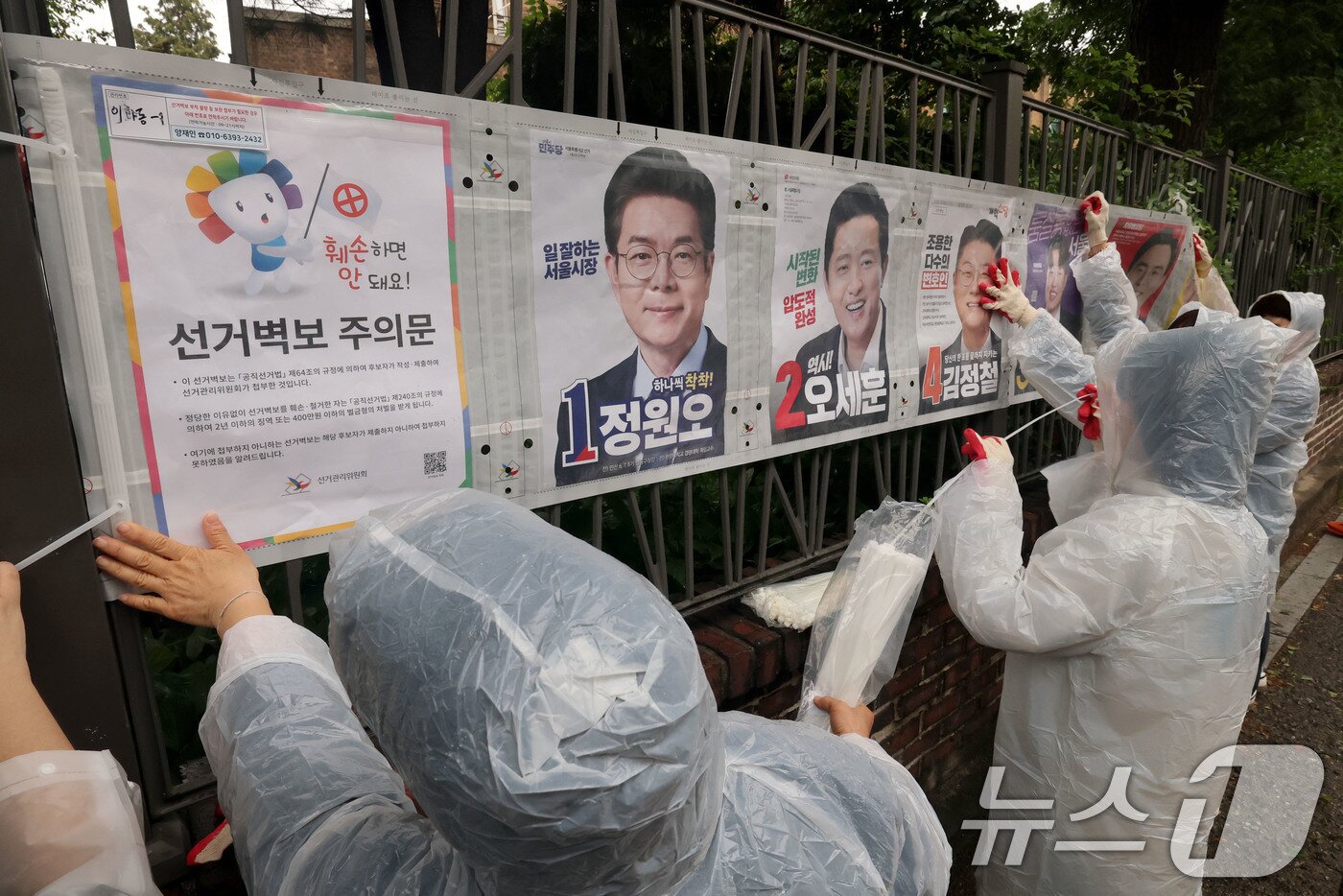 본문 이미지 - 제9회 전국동시지방선거 공식 선거운동이 시작된 21일 오전 서울 종로구 예술가의 집 담장에 서울시선관위 직원들이 선거벽보를 첩부하고 있다. 2026.5.21 ⓒ 뉴스1 이광호 기자