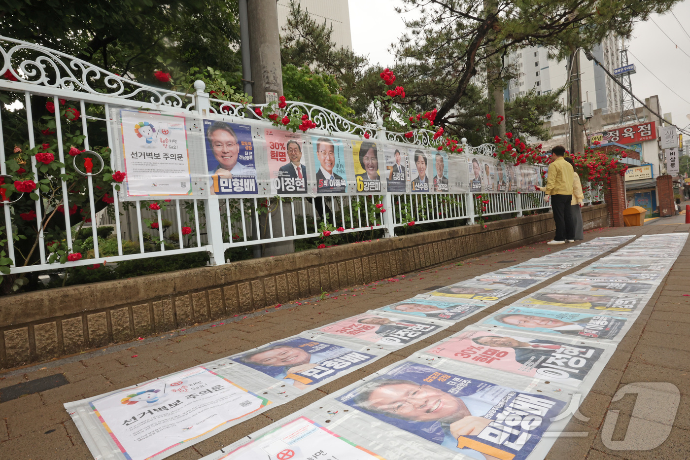 (광주=뉴스1) 박지현 기자 = 제9회 전국동시지방선거 공식 선거 운동 첫날인 21일 광주 북구 매곡동의 한 아파트 앞 정문에 광주 북구 관계자들이 선거벽보를 부착하고 있다. 20 …