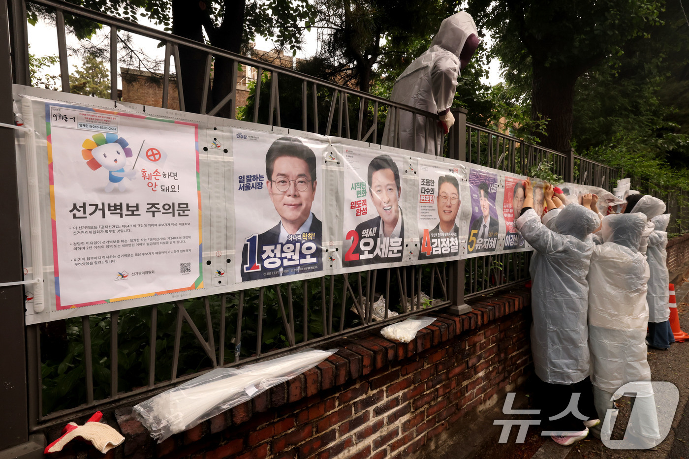 (서울=뉴스1) 이광호 기자 = 제9회 전국동시지방선거 공식 선거운동이 시작된 21일 오전 서울 종로구 예술가의 집 담장에 서울시선관위 직원들이 선거벽보를 첩부하고 있다. 2026 …
