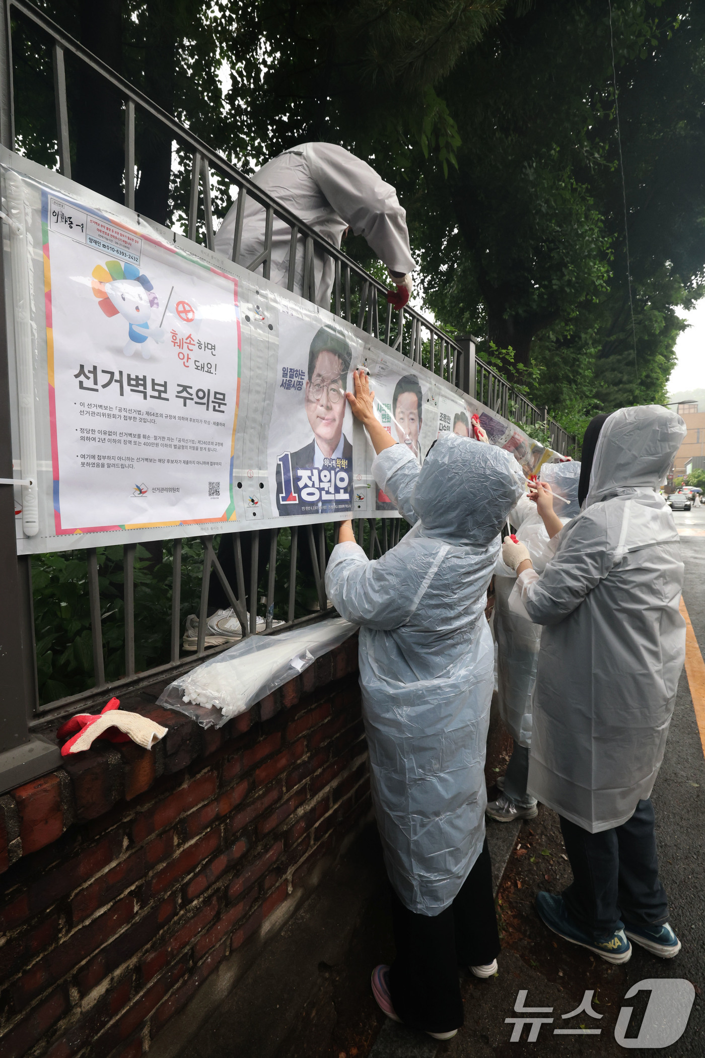 (서울=뉴스1) 이광호 기자 = 제9회 전국동시지방선거 공식 선거운동이 시작된 21일 오전 서울 종로구 예술가의 집 담장에 서울시선관위 직원들이 선거벽보를 첩부하고 있다. 2026 …