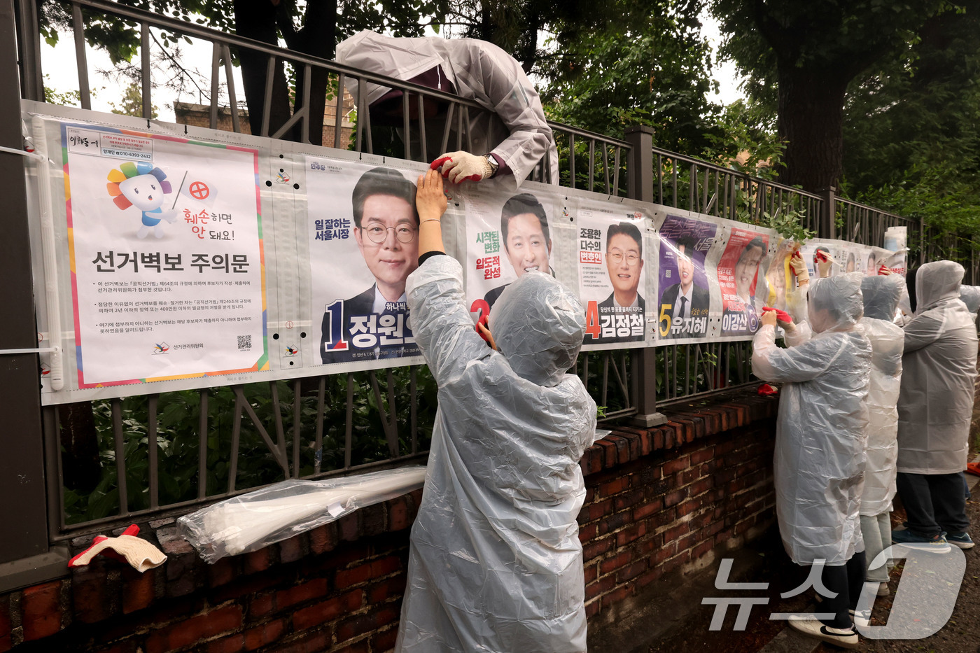 (서울=뉴스1) 이광호 기자 = 제9회 전국동시지방선거 공식 선거운동이 시작된 21일 오전 서울 종로구 예술가의 집 담장에 서울시선관위 직원들이 선거벽보를 첩부하고 있다. 2026 …