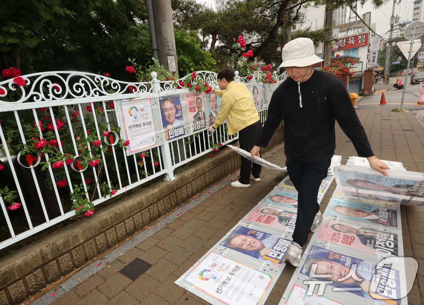 (광주=뉴스1) 박지현 기자 = 제9회 전국동시지방선거 공식 선거 운동 첫날인 21일 광주 북구 매곡동의 한 아파트 앞 정문에 광주 북구 관계자들이 선거벽보를 부착하고 있다. 20 …