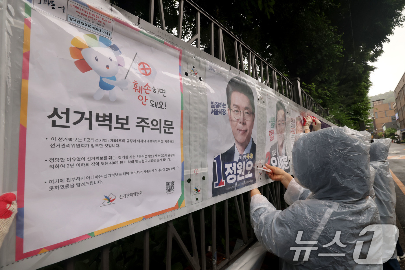 (서울=뉴스1) 이광호 기자 = 제9회 전국동시지방선거 공식 선거운동이 시작된 21일 오전 서울 종로구 예술가의 집 담장에 서울시선관위 직원들이 선거벽보를 첩부하고 있다. 2026 …