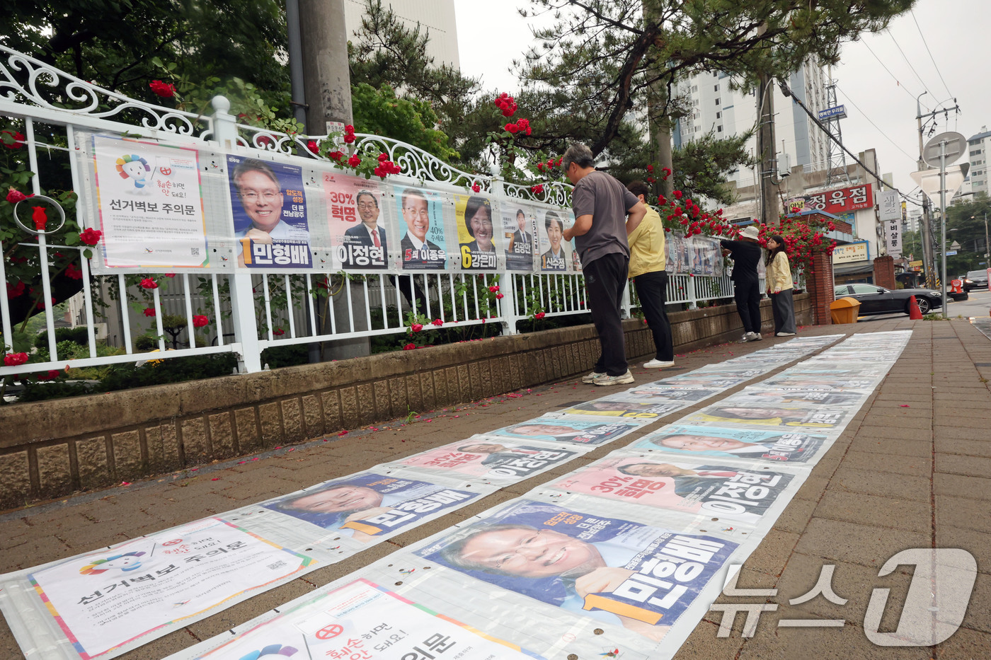 (광주=뉴스1) 박지현 기자 = 제9회 전국동시지방선거 공식 선거 운동 첫날인 21일 광주 북구 매곡동의 한 아파트 앞 정문에 광주 북구 관계자들이 선거벽보를 부착하고 있다. 20 …
