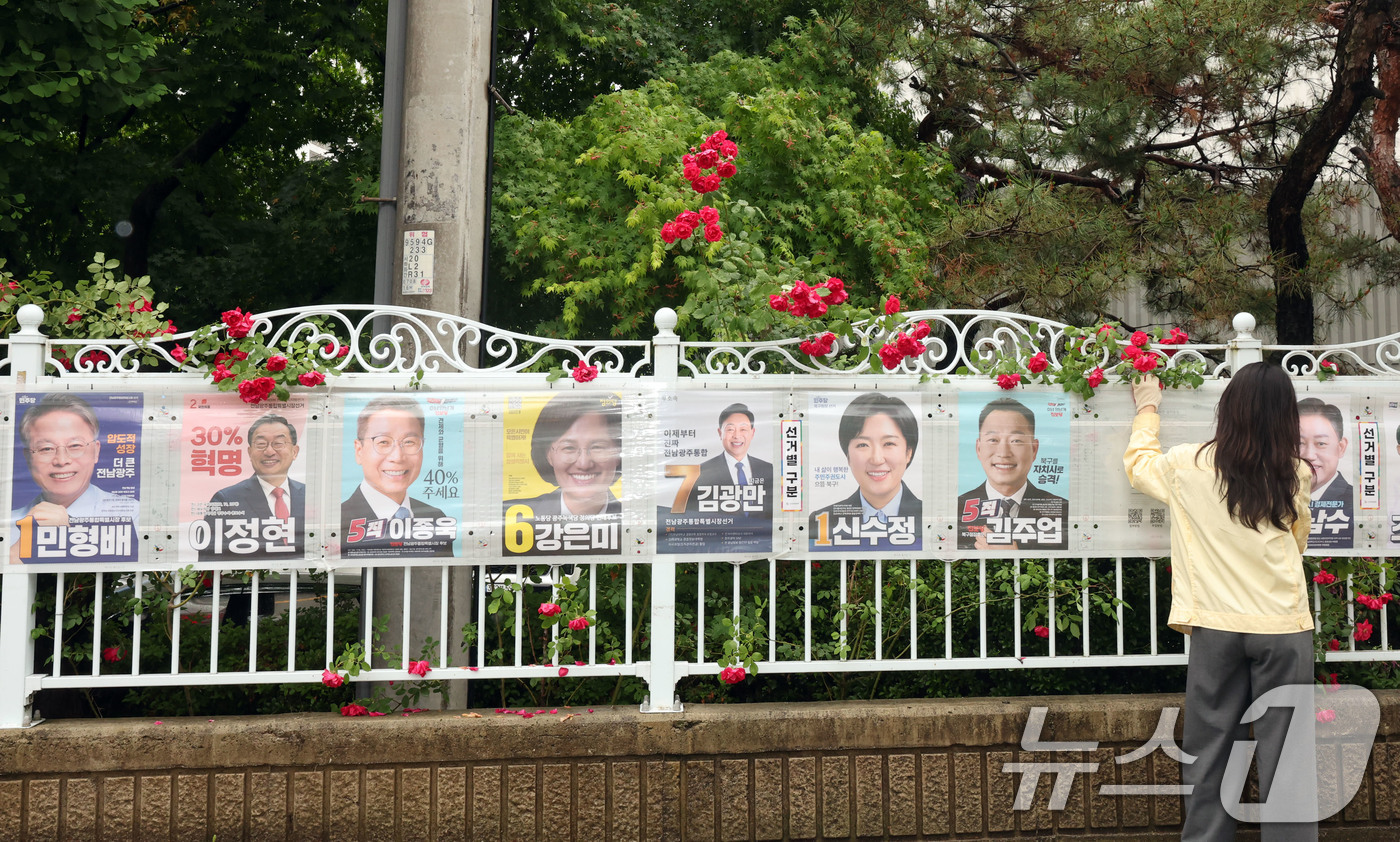 (광주=뉴스1) 박지현 기자 = 제9회 전국동시지방선거 공식 선거 운동 첫날인 21일 광주 북구 매곡동의 한 아파트 앞 정문에 광주 북구 관계자들이 선거벽보를 부착하고 있다. 20 …